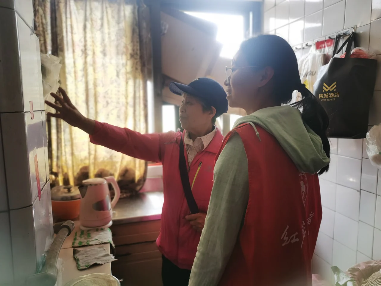 社区工作人员入户走访，与居民交流居家服务需要